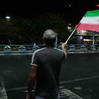 A pro-government demonstrator waves an Iranian flag in a gathering commemorating the late Iranian Supreme Leader Ayatollah Ali Khamenei at a square in Tehran, Iran, July 11, 2026. (AP Photo/Vahid Salemi)