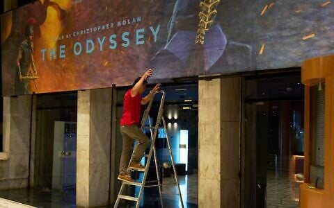 A worker installs a hand-painted billboard, painted by artist Virginia Axioti, for Christopher Nolan’s upcoming film 'The Odyssey,' starring Matt Damon as Odysseus, outside Athens’ Athinaion cinema, where every film is promoted with a hand-painted billboard, July 11, 2026 (AP Photo/Petros Giannakouris)