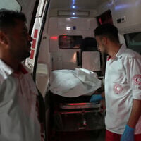 Palestinian paramedics stand at the back of an ambulance after arriving at Al-Aqsa Hospital with the body of a person killed in an Israeli strike in Deir al-Balah, central Gaza Strip, July 15, 2026. (Abdel Kareem Hana/AP)