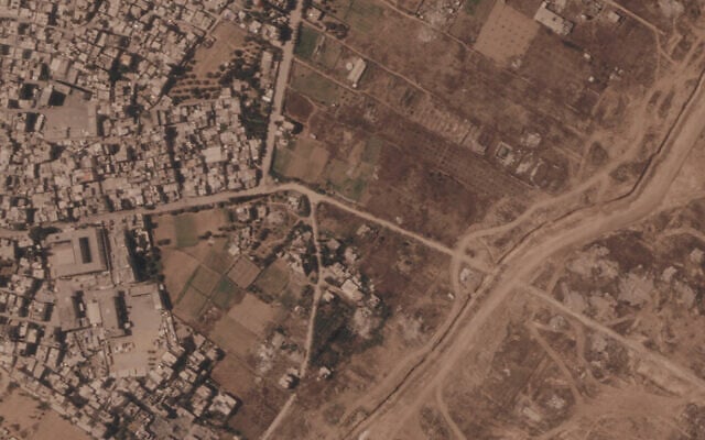 This satellite image from Planet Labs PBC shows a section of an earthen barrier being built by the Israeli military, right side of image moving top to bottom, in the central Gaza Strip, July 1, 2026. At left is the Maghazi camp, and on the other side are homes demolished by the military. (Planet Labs PBC via AP)