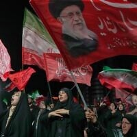 Demonstrators wave Iranian and religious flags, including one depicting the late Supreme Leader Ali Khamenei, during a pro-government gathering in Tehran, July 17, 2026 (AP Photo/Vahid Salemi)