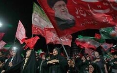 Demonstrators wave Iranian and religious flags, including one depicting the late Supreme Leader Ali Khamenei, during a pro-government gathering in Tehran, July 17, 2026 (AP Photo/Vahid Salemi)