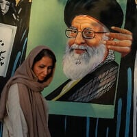 A woman walks past a mural depicting a portrait of the late Iranian Supreme Leader Ayatollah Ali Khamenei, who was killed in the US and Israel strike on February 28, in downtown Tehran, Iran, July 18, 2026 (AP Photo/Vahid Salemi)