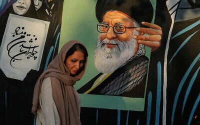 A woman walks past a mural depicting a portrait of the late Iranian Supreme Leader Ayatollah Ali Khamenei, who was killed in the US and Israel strike on February 28, in downtown Tehran, Iran, July 18, 2026 (AP Photo/Vahid Salemi)