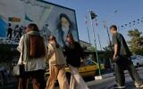 People cross the Islamic Revolution Street under a mural depicting a portrait of the Islamic Republic founder Ruhollah Khomeini in downtown Tehran, Iran, July 18, 2026. (AP/Vahid Salemi)