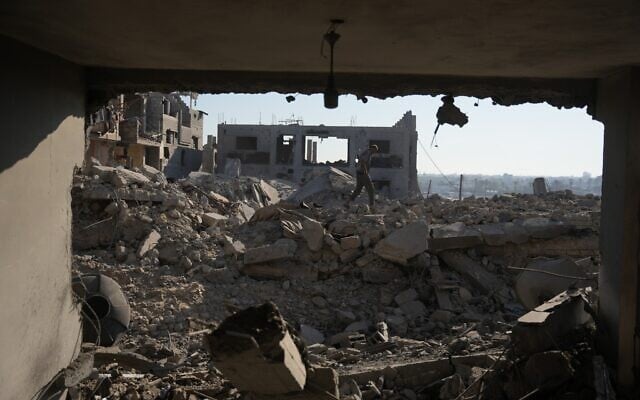 A Palestinian man inspects a destroyed building following an Israeli airstrike in Deir al-Balah, central Gaza Strip, July 19, 2026. (AP/Abdel Kareem Hana)