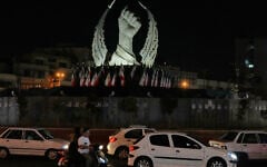 Vehicles drive past a monument depicting the clenched fist of the late Iranian supreme leader ayatollah Ali Khamenei, who was killed at the start of the US-Israel war with Iran, in Islamic Revolution Square in Tehran, July 19, 2026. (AP Photo/Vahid Salemi)