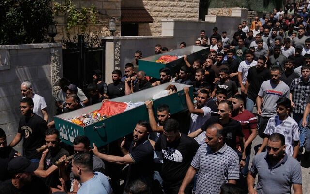 Palestinians carry the bodies of Awda Farakhneh, 53, and Ahmed Abu Mokho, 26, who, according to the health authorities, were killed by Israeli army fire following a settler attack, during their funeral in the West Bank town of Deir Jarir, northeast Ramallah, July 20, 2026. (AP Photo/Majdi Mohammed)