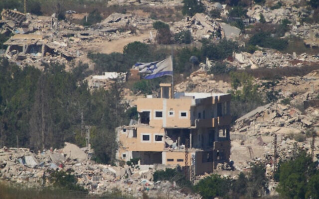An Israeli flag hangs on a damaged building in southern Lebanon as seen from northern Israel, July 21, 2026. (AP Photo/Ariel Schalit)