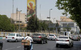 Vehicles drive past a billboard depicting the clenched fist of the late Iranian supreme leader Ayatollah Ali Khamenei, in Tehran, Iran, July 21, 2026. (AP/ Vahid Salemi)