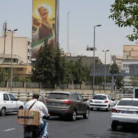 Vehicles drive past a billboard depicting the clenched fist of the late Iranian supreme leader Ayatollah Ali Khamenei, in Tehran, Iran, July 21, 2026. (AP/ Vahid Salemi)