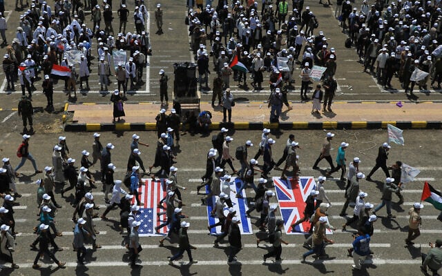 Demonstrators march over depictions of the flags of the United States, Israel and the United Kingdom during a rally against the Saudi-led coalition in Sanaa, Yemen, July 22, 2026. (AP/Osamah Abdulrahman)