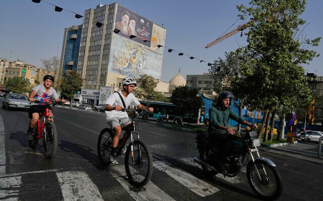 A man rides on his motorbike as boys ride on their bicycles in downtown Tehran, Iran, July 22, 2026. (AP/Vahid Salemi) A man rides on his motorbike as boys ride on their bicycles in downtown Tehran, Iran, July 22, 2026. (AP/Vahid Salemi)