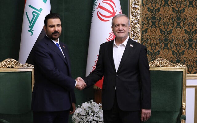 Iraqi Prime Minister Ali al-Zaidi, left, shakes hands with Iranian President Masoud Pezeshkian during their meeting in Tehran, Iran, July 22, 2026. (Iranian Presidency Office via AP)