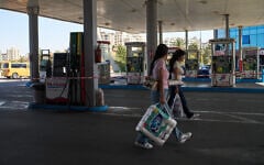 Palestinian women walk past pumps of a closed gas station during a fuel shortage in the West Bank city of Ramallah, July 23, 2026. (AP Photo/Leo Correa)