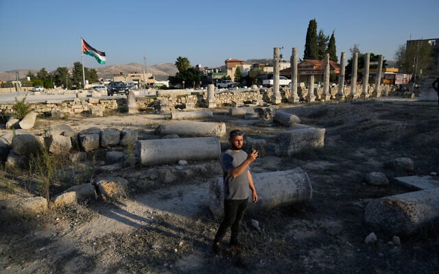 A Palestinian visitor takes a photo at the historical site in the West Bank town of Sebastia November 20, 2025. (AP Photo/Nasser Nasser)