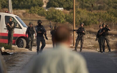 Members of Israeli security forces stand guard during a raid in the village of Sarra, near the West Bank city of Nablus, July 25, 2026. (AP Photo/Leo Correa)