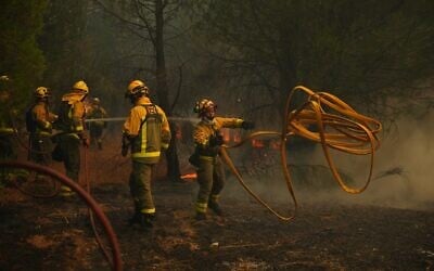 Firefighters battle a wildfire in San Martin de Valdeiglesias, west of Madrid, Spain, July 26, 2026. (AP Photo/Manu Fernandez)