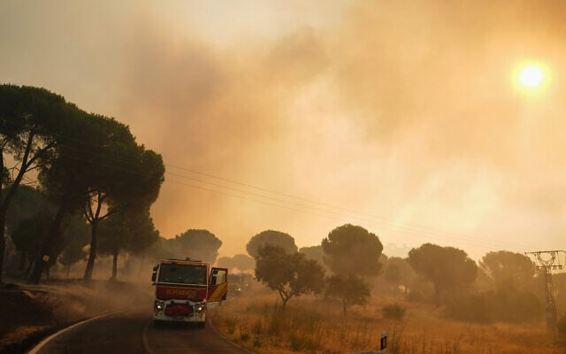 Fire engines stop on a road as smoke rises from a wildfire in San Martin de Valdeiglesias, west of Madrid, Spain, July 26, 2026. (AP Photo/ Manu Fernandez) Fire engines stop on a road as smoke rises from a wildfire in San Martin de Valdeiglesias, west of Madrid, Spain, July 26, 2026. (AP Photo/ Manu Fernandez)