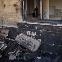Palestinians pray inside a mosque that was burned during an attack by Israeli settlers in the West Bank village of Qusra, early in the morning of July 26, 2026. (AP Photo/Leo Correa)