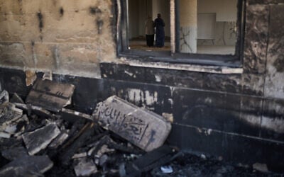Palestinians pray inside a mosque that was burned during an attack by Israeli settlers in the West Bank village of Qusra, early in the morning of July 26, 2026. (AP Photo/Leo Correa)