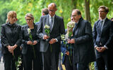 From left, Family Minister Karin Prien, Justice Minister Stefanie Hubig, German Chancellor Friedrich Merz, and German Interior Minister Alexander Dobrindt carry flowers as they visit Tiergarten park after an attacker rammed a vehicle into a crowd near Berlin’s annual Pride event, in Berlin, July 26, 2026. (Annegret Hilse/Pool Photo via AP)
