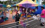 A police officer responds after a shooting at Seattle Center during the Bite of Seattle food festival July 26, 2026, in Seattle, Wash. (AP Photo/Lindsey Wasson)