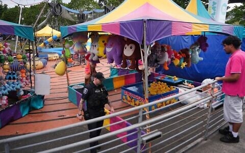 A police officer responds after a shooting at Seattle Center during the Bite of Seattle food festival July 26, 2026, in Seattle, Wash. (AP Photo/Lindsey Wasson)