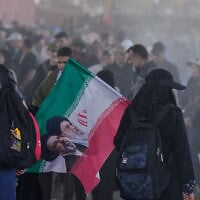 Iranian Shite pilgrims carrying Iranian flags arrive at the Al-Mundheriya border crossing to join millions of Muslims heading to the holy city of Karbala for the annual Arbaeen pilgrimage, in Diyala, Iraq, July 27, 2026. (AP Photo/Hadi Mizban)