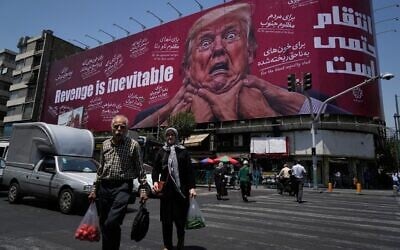 Pedestrians walk past a billboard depicting US President Donald Trump being grabbed by the neck alongside the message “Revenge is inevitable” in English and Farsi, in Tehran, Iran, July 27, 2026. (AP Photo/Vahid Salemi)