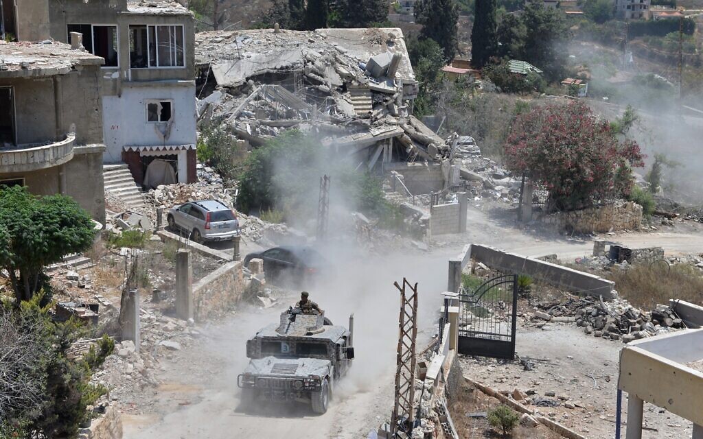 A Lebanese military vehicle drives past homes damaged during the war in the southern village of Zawtar al-Gharbieh, Lebanon, July 27, 2026. (AP Photo/Mustafa Jamalddine)