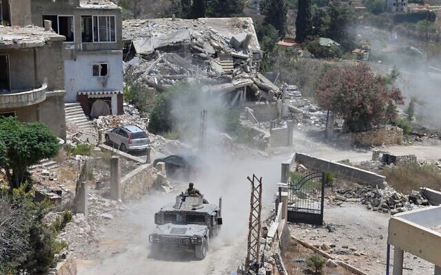 A Lebanese military vehicle drives past homes damaged during the war in the southern village of Zawtar al-Gharbieh, Lebanon, July 27, 2026. (AP Photo/Mustafa Jamalddine)