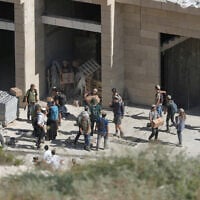 Israeli settlers carry cardboard boxes from a building under construction in the Palestinian village of Tell, in the West Bank, July 31, 2026. (AP Photo/Majdi Mohammed)