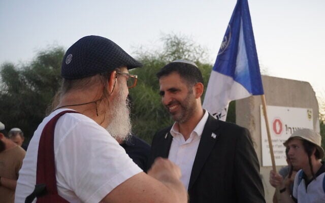 Communications Minister Shlomo Karhi greets a participant in a march to the Gaza border in support of Jewish settlement in the territory on July 19, 2026. (Charlie Summers/Times of Israel)