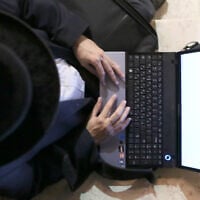 Illustrative: An ultra-Orthodox jewish man uses a laptop. (Nati Shohat/FLASH90)