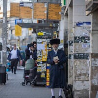 People walk along a street in the ultra-Orthodox city of Bnei Brak in central Israel, March 2, 2026. (Chaim Goldberg/Flash90)