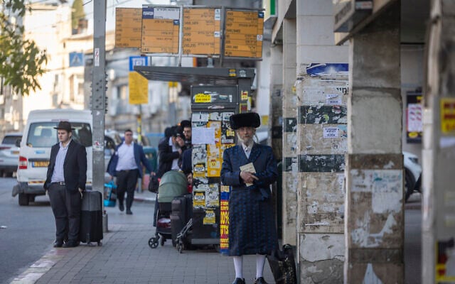 People walk along a street in the ultra-Orthodox city of Bnei Brak in central Israel, March 2, 2026. (Chaim Goldberg/Flash90)