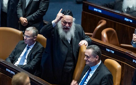 MK Yitzhak Goldknopf, center, alongside Likud's Justice Minister Yariv Levin, left, and Defense Minister Israel Katz, right, during a Knesset vote on a bill to freeze arrests of Haredi draft evaders in Jerusalem, July 14, 2026. (Chaim Goldberg/Flash90)