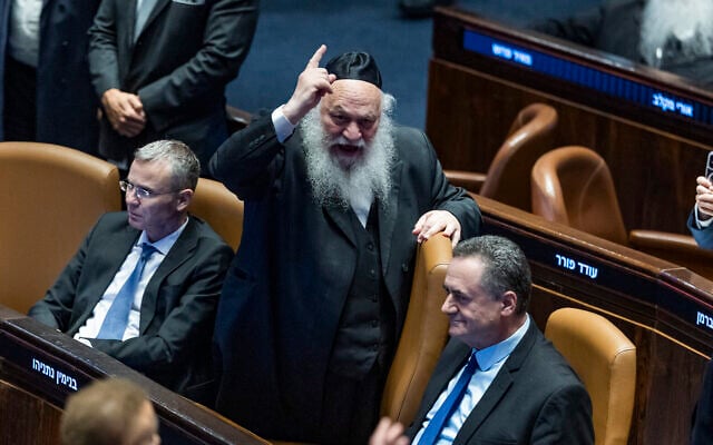 MK Yitzhak Goldknopf, center, alongside Likud's Justice Minister Yariv Levin, left, and Defense Minister Israel Katz, right, during a Knesset vote on a bill to freeze arrests of Haredi draft evaders in Jerusalem, July 14, 2026. (Chaim Goldberg/Flash90)