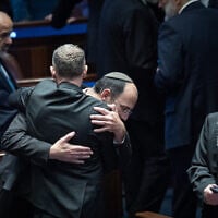 Religious Zionism MK Simcha Rothman celebrates with Justice Minister Yariv Levin (back to camera) following the passage of a law to weaken the powers of the attorney general, at the Knesset plenum in Jerusalem on July 15, 2026. (Yonatan Sindel/Flash90)