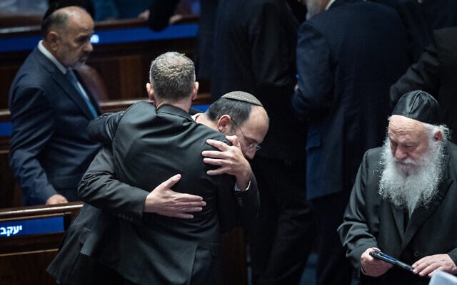 Religious Zionism MK Simcha Rothman celebrates with Justice Minister Yariv Levin following the passage of a bill to split the duties and powers currently held by the attorney general between two separate officeholders, at the Knesset plenum in Jerusalem on July 15, 2026. (Yonatan Sindel/Flash90)