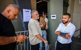People stand at polling station during the Likud party's primaries, which were halted following a court order, at Menora Mivtachim Arena in Tel Aviv, July 16, 2026 (Avshalom Sassoni/Flash90)