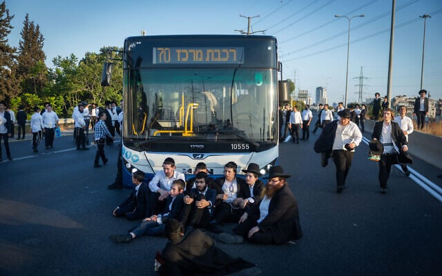Ultra-Orthodox Jewish men block a bus on Route 4, near Bnei Brak, during a demonstration against the arrest of draft evaders, on July 16, 2026. (Chaim Goldberg/Flash90) Ultra-Orthodox Jewish men block a bus on Route 4, near Bnei Brak, during a demonstration against the arrest of draft evaders, on July 16, 2026. (Chaim Goldberg/Flash90)