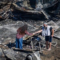 People inspect damage caused by a fire on July 18 in the Israeli settlement of Havat Gilad in the West Bank, seen on July 19, 2026. (Chaim Goldberg/Flash90)