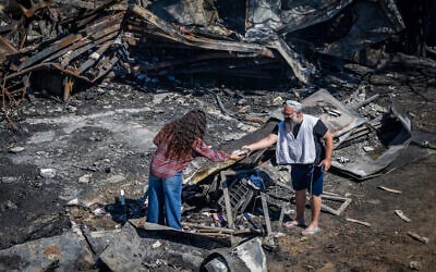 People inspect damage caused by a fire on July 18 in the Israeli settlement of Havat Gilad in the West Bank, seen on July 19, 2026. (Chaim Goldberg/Flash90) People inspect damage caused by a fire on July 18 in the Israeli settlement of Havat Gilad in the West Bank, seen on July 19, 2026. (Chaim Goldberg/Flash90)