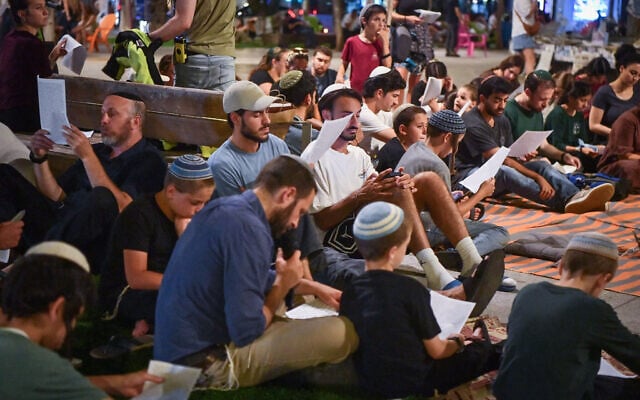 People attend a public reading of the Book of Lamentations for Tisha B’Av at Dizengoff Square in Tel Aviv, July 22, 2026. (Avshalom Sassoni/Flash90)