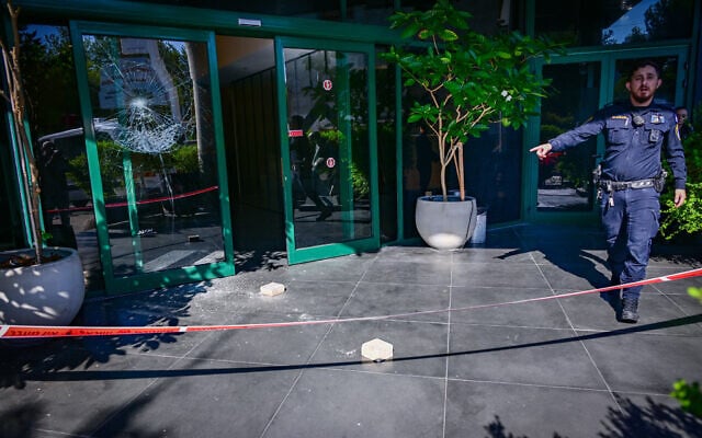 The damaged entrance door to the Channel 12 offices in Tel Aviv after it was shattered by an unknown suspect overnight, July 28, 2026. (Avshalom Sassoni/Flash90)