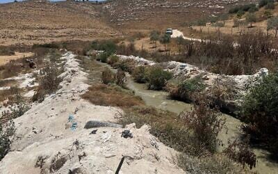 Contaminated water flows in the Hebron Stream below Palestinian village of ad-Dahariya, between banks coated in stone dust, July 14, 2026. (Sue Surkes/Times of Israel) Contaminated water flows in the Hebron Stream below Palestinian village of ad-Dahariya, between banks coated in stone dust, July 14, 2026. (Sue Surkes/Times of Israel)