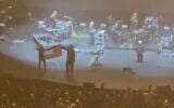Members of the band Massive Attack display a Palestinian flag at their concert in Singapore, July 29, 2026. (X video: used in accordance with Clause 27a of the Copyright Law)