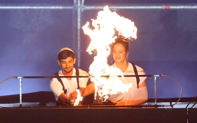 Israeli Paralympic taekwondo champion Asaf Yasur and Israeli Olympic judo star Inbar Lanir light the Maccabiah torch at the opening ceremony of the Maccabiah Games at Teddy Stadium in Jerusalem, July 1, 2026 (Maccabiah/Gilad Kavalerchik)